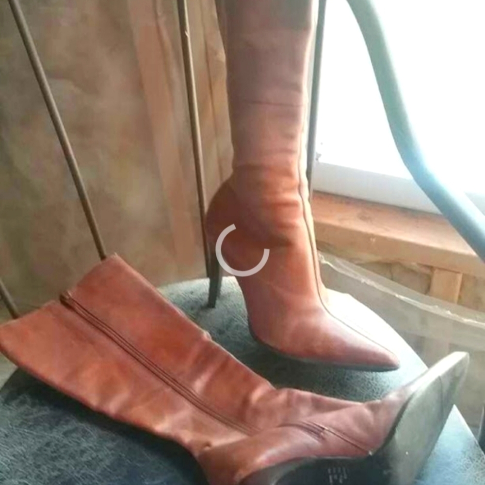 Woman's leather high heel knee high boots .